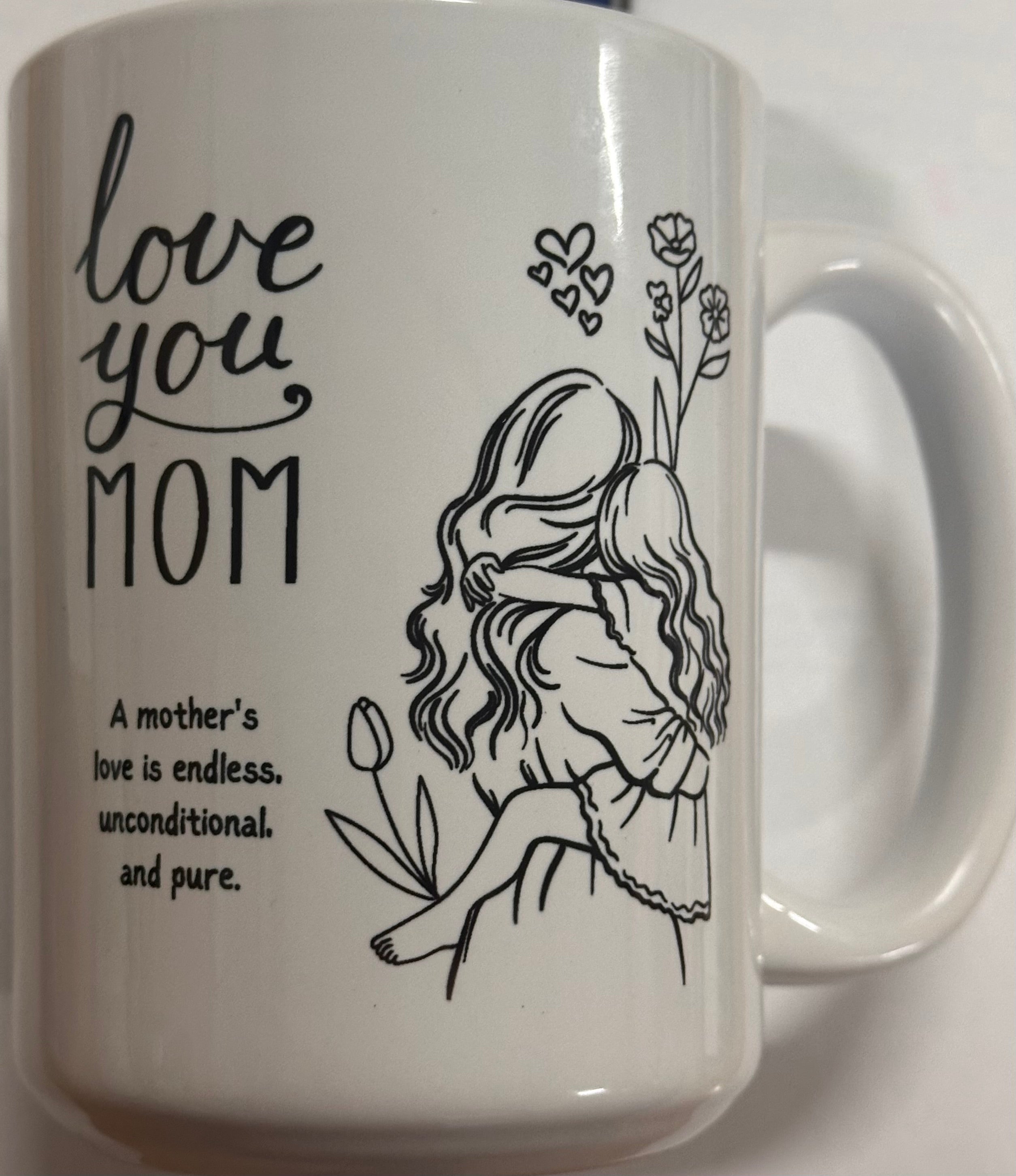 White mug with black illustrations and text 'love you MOM' on a white background